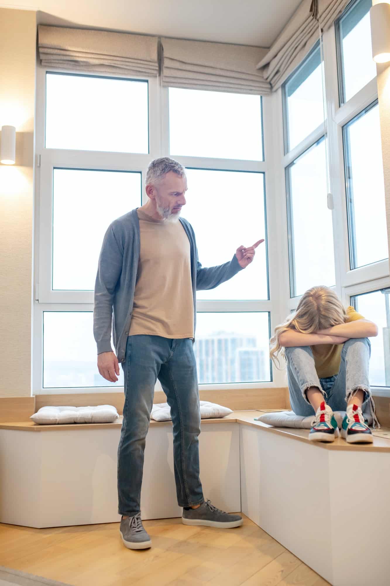 A gray-haired man having a hard talk with his teenage daughter