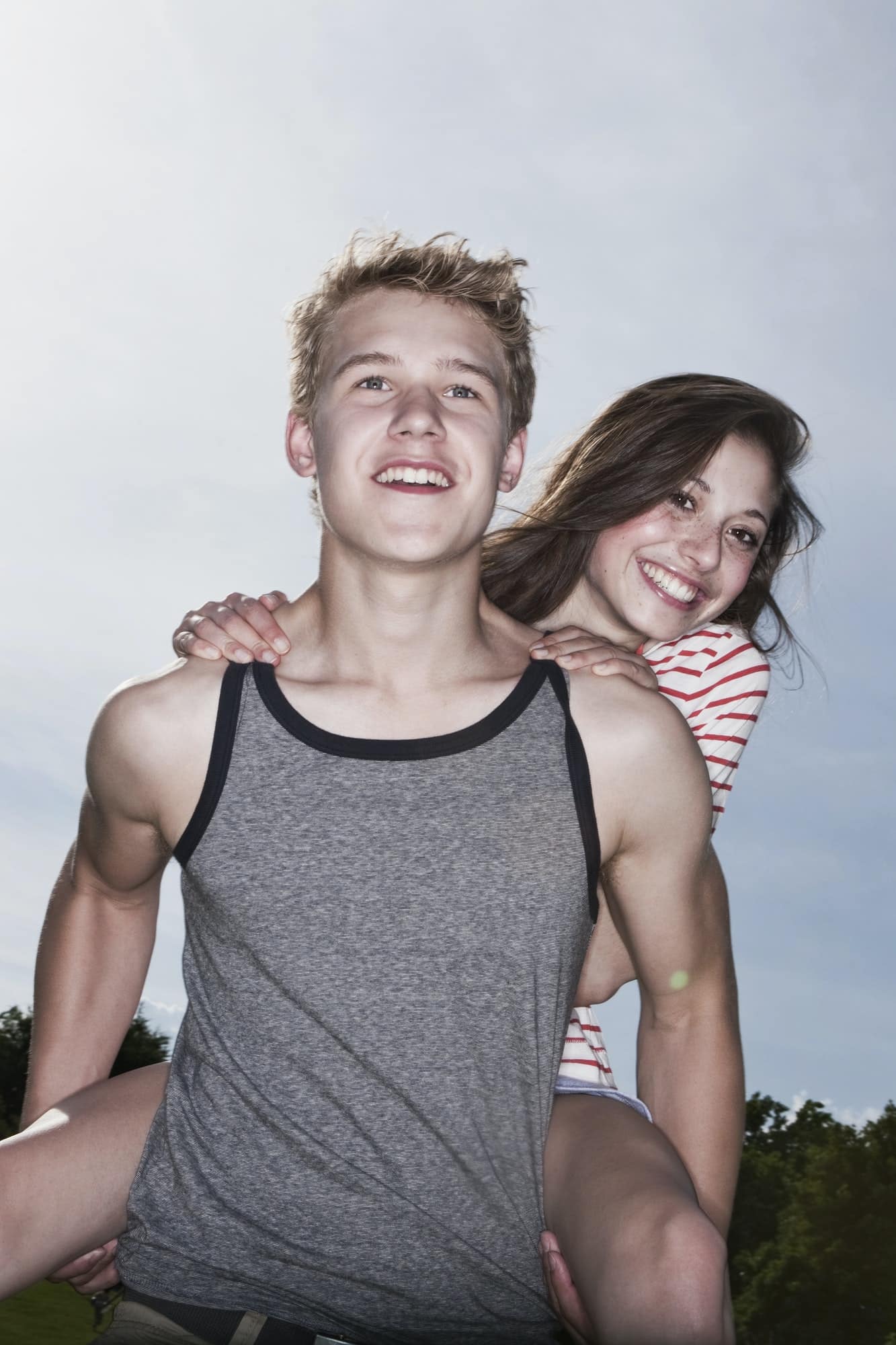 Germany, Berlin, Teenage boy carrying a girl piggy back